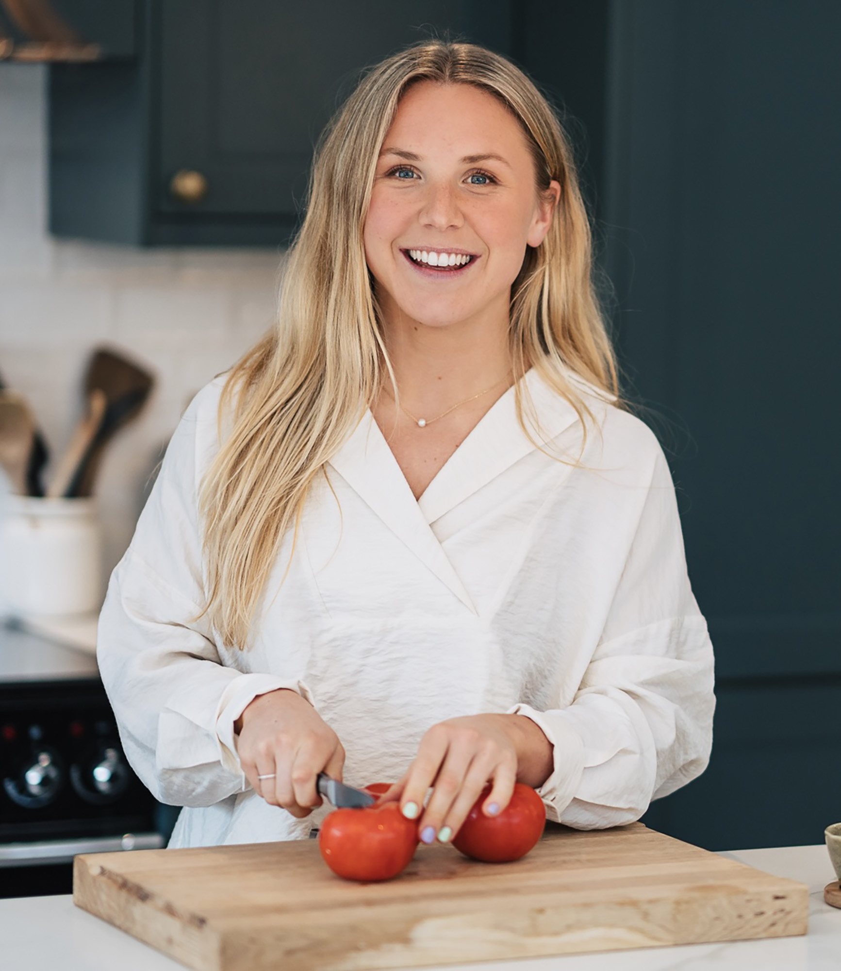 Gigi preparing fresh food in a kitchen as part of a balanced, hormone-supportive lifestyle